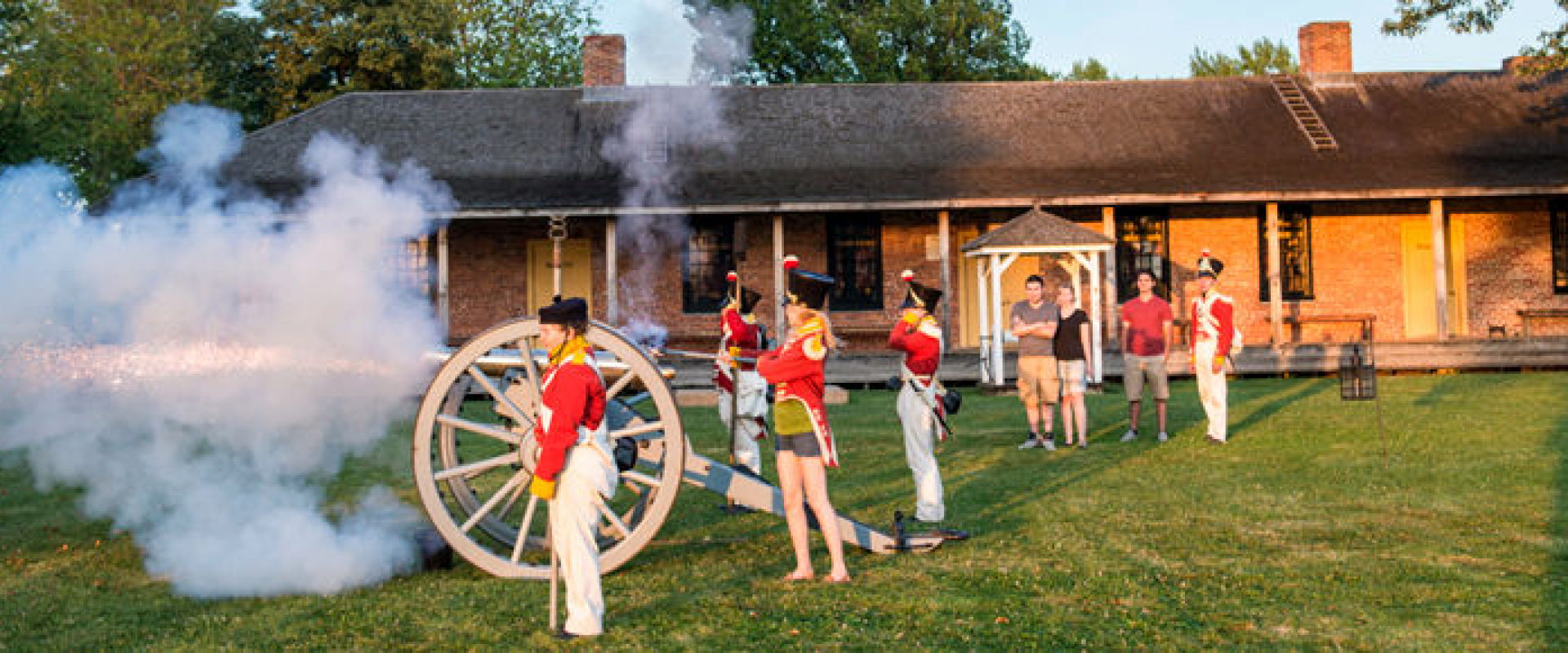 Re-enactors in 19th century military costumes demonstrate cannon firing at Fort Malden. 