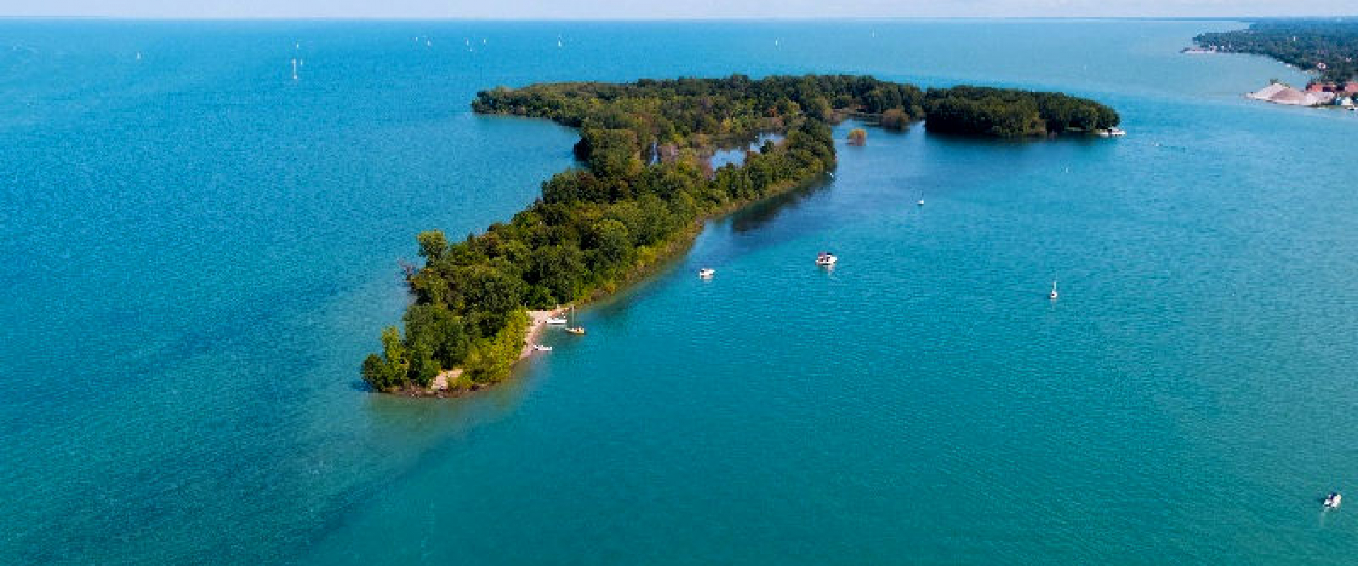 Peche Island, a small spit of land, peaks out of the blue waters of the Detroit River. 