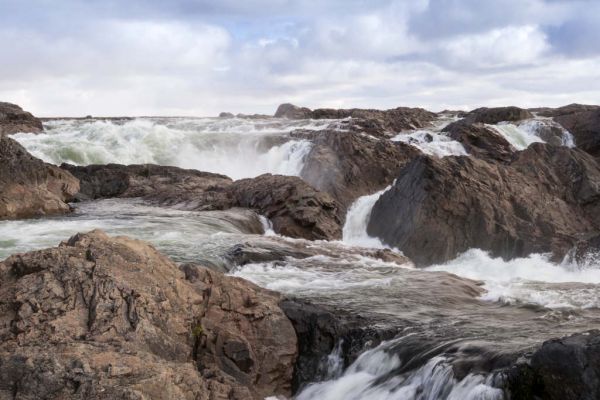 White water of the Kazan River rushes past the cracked and jagged rocks of the Kazan Falls.