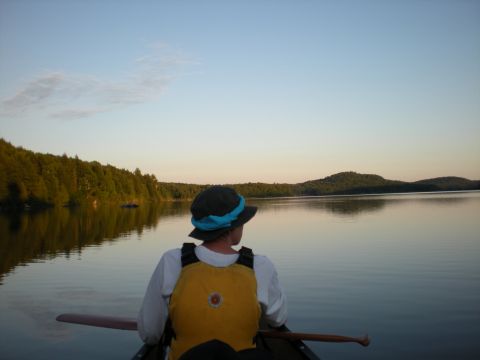 Un canotier regarde au-delà de l'horizon des eaux calmes et tranquilles de la rivière Mattawa.
