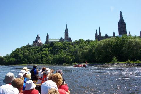 Un groupe de pagayeurs fait la fête sur la rivière des Outaouais, devant la colline du Parlement.