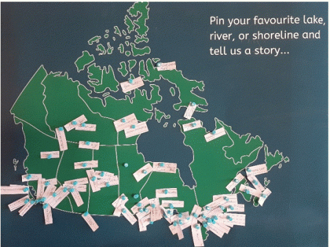Carte du Canada sur laquelle sont épinglés des morceaux de papier indiquant les noms des plans d'eau. La légende sur la carte indique: « Épinglez votre lac, votre rivière ou votre rivage préféré et racontez-nous une histoire... ».