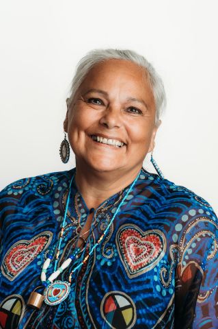 Smiling headshot of Elder Sheila De Corte in studio lighting
