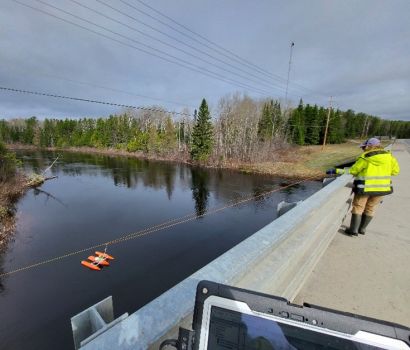 Lauren Bourke remorquant un bateau amarré sur la rivière Blackwater, à Beardmore, en Ontario, afin de mesurer le débit à l'aide d'un profileur acoustique de courant Doppler (ADCP), le 15 mai 2025 (photo de Tanner Booth).