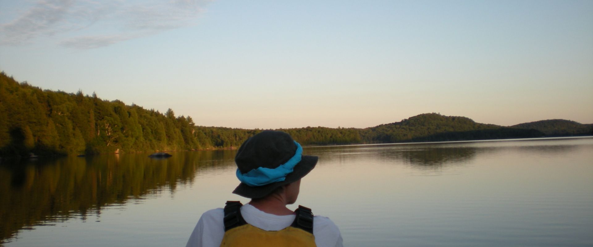 Un canotier regarde au-delà de l'horizon des eaux calmes et tranquilles de la rivière Mattawa.