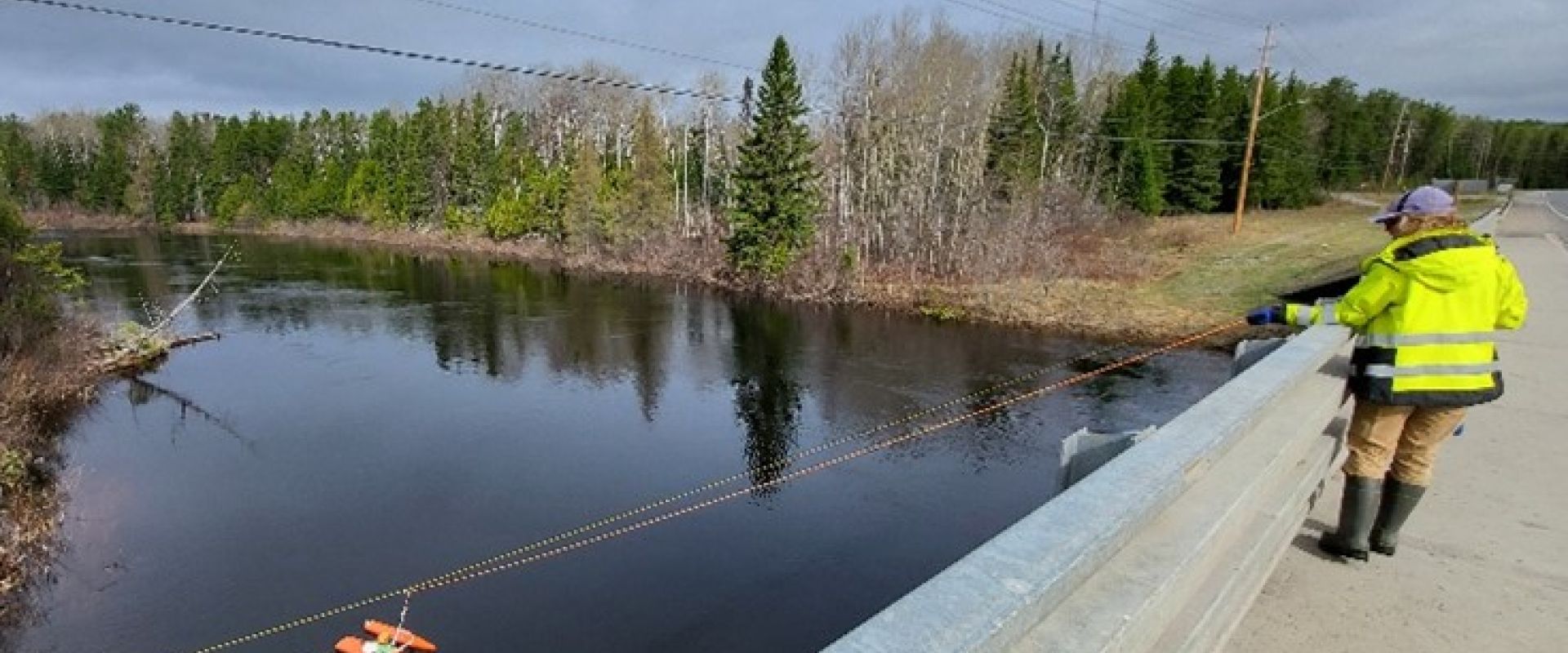 Lauren Bourke remorquant un bateau amarré sur la rivière Blackwater, à Beardmore, en Ontario, afin de mesurer le débit à l'aide d'un profileur acoustique de courant Doppler (ADCP), le 15 mai 2025 (photo de Tanner Booth).